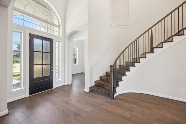 27403 Laurel Bay Ct, Katy, TX 77494 - foyer with wood-type flooring, stairs, a high ceiling, baseboards, and arched walkways