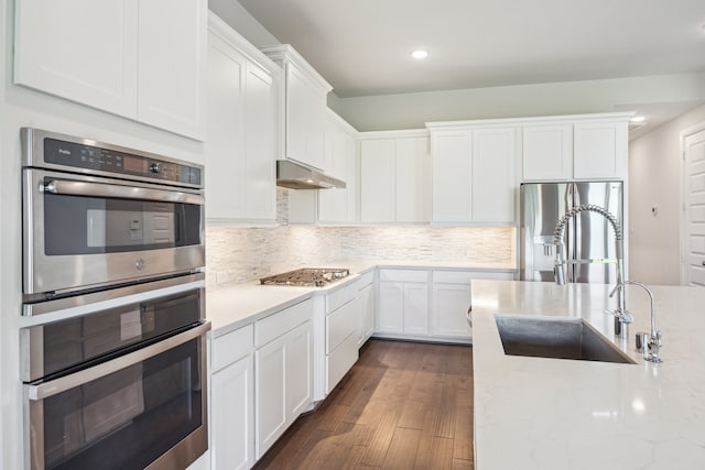 27403 Laurel Bay Ct, Katy, TX 77494 - kitchen with a sink, stainless steel appliances, white cabinetry, dark wood-style flooring, and recessed lighting