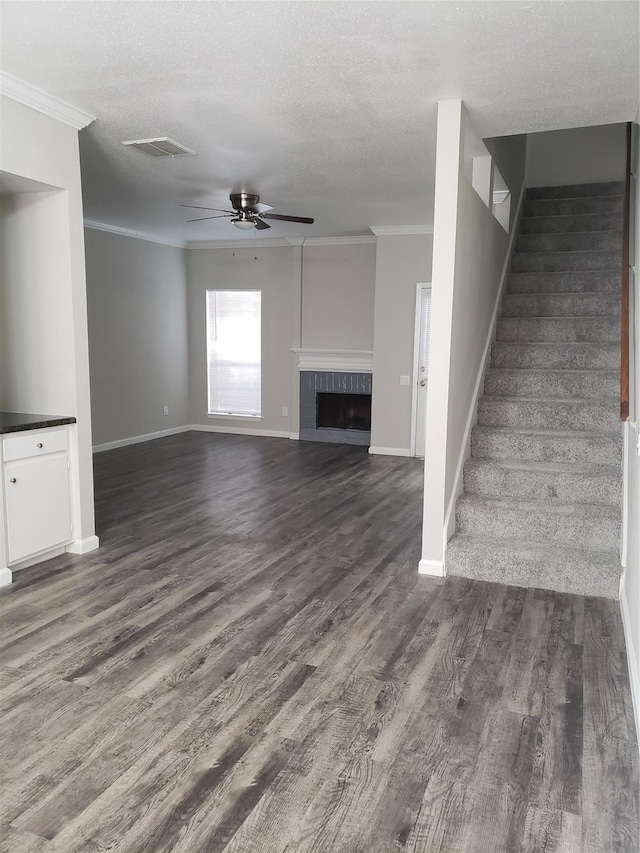 11710 Southlake Dr, Houston, TX 77077 - unfurnished living room featuring ceiling fan, crown molding, dark wood-type flooring, stairway, and baseboards