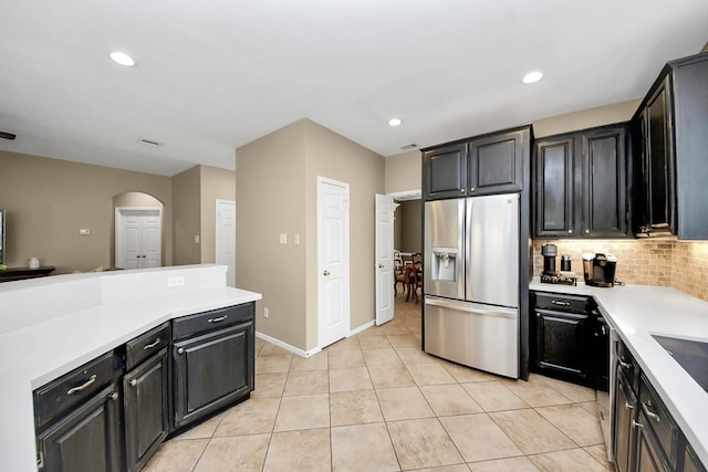 111 Knoll Forest Dr, Sugar Land, TX 77479 - kitchen with stainless steel fridge with ice dispenser, light countertops, decorative backsplash, arched walkways, and recessed lighting
