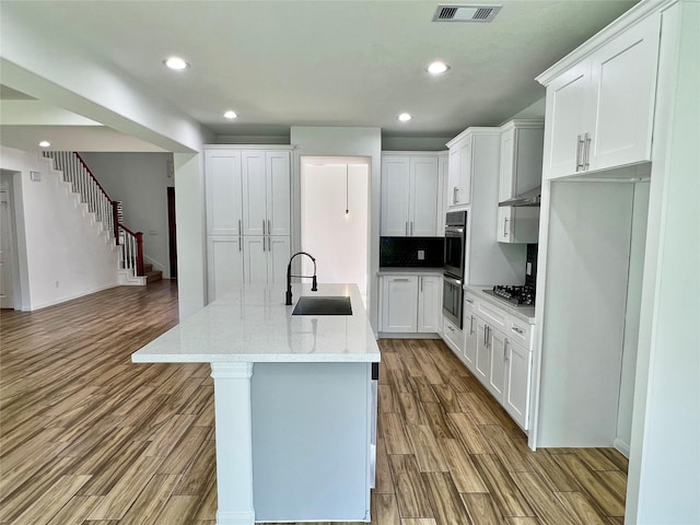 9630 Landry Blvd, Spring, TX 77379 - kitchen with a sink, appliances with stainless steel finishes, wood finished floors, a center island with sink, and recessed lighting