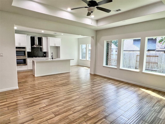 9630 Landry Blvd, Spring, TX 77379 - kitchen featuring wall chimney exhaust hood, open floor plan, double oven, light wood-style flooring, and recessed lighting