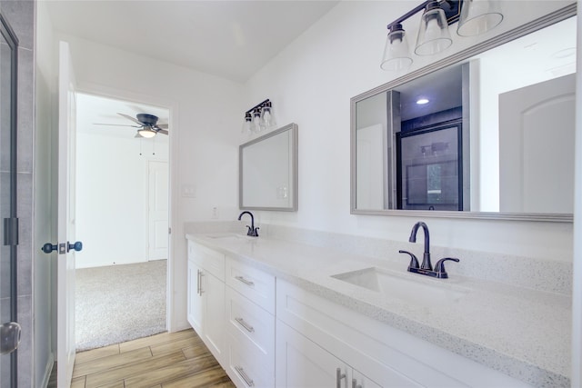9630 Landry Blvd, Spring, TX 77379 - bathroom featuring wood finished floors, a stall shower, a ceiling fan, and double vanity