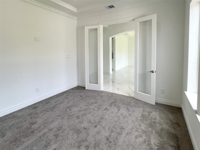 126 Lakeland Cir, Rosharon, TX 77583 - unfurnished bedroom featuring arched walkways, french doors, baseboards, carpet, and crown molding