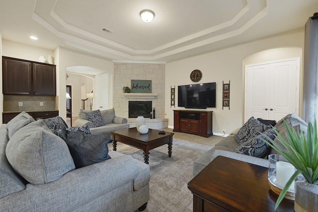 14023 Loramie Creek Ct, Houston, TX 77044 - living area featuring a tray ceiling, arched walkways, and a stone fireplace