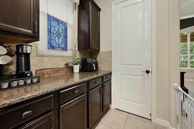 14023 Loramie Creek Ct, Houston, TX 77044 - kitchen featuring decorative backsplash, dark brown cabinetry, and light tile patterned floors