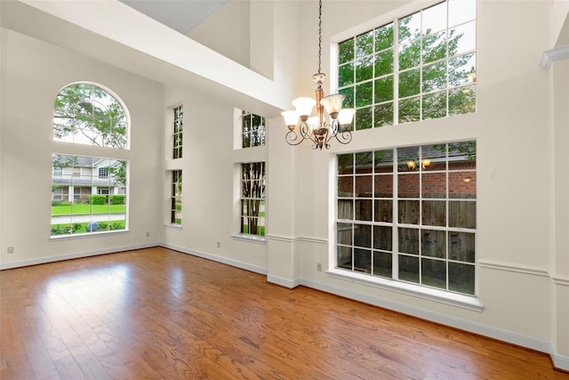 14306 Medlowe Ct, Cypress, TX 77429 - unfurnished dining area featuring a towering ceiling, a chandelier, plenty of natural light, and wood finished floors