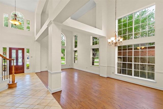 14306 Medlowe Ct, Cypress, TX 77429 - foyer with a towering ceiling, healthy amount of natural light, a chandelier, ornate columns, and baseboards