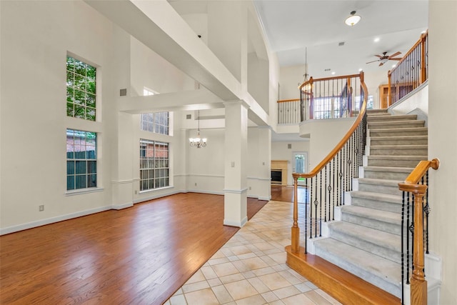 14306 Medlowe Ct, Cypress, TX 77429 - foyer entrance with a towering ceiling, a chandelier, ceiling fan, stairs, and a glass covered fireplace