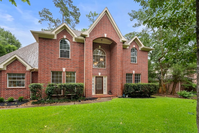 6 Cranberry Bnd, The Woodlands, TX 77381 - view of front of property featuring brick siding, a front lawn, and a shingled roof