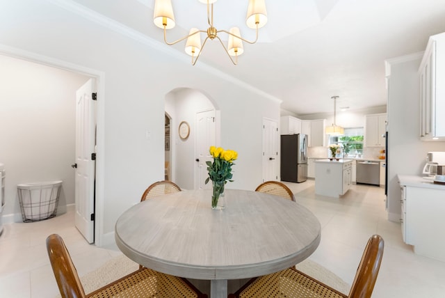 6 Cranberry Bnd, The Woodlands, TX 77381 - dining space with a chandelier, arched walkways, light tile patterned floors, crown molding, and baseboards