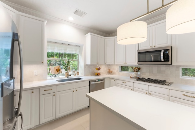 6 Cranberry Bnd, The Woodlands, TX 77381 - kitchen featuring appliances with stainless steel finishes, a sink, healthy amount of natural light, decorative backsplash, and crown molding