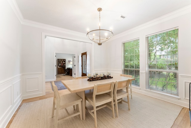 6 Cranberry Bnd, The Woodlands, TX 77381 - dining room with a chandelier, ornamental molding, a decorative wall, wainscoting, and light wood-style flooring