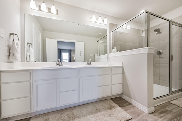 12738 Beatrice Terrace Dr, Humble, TX 77346 - bathroom with a shower stall, double vanity, baseboards, and wood finished floors