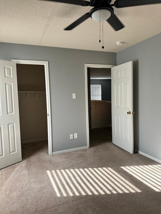 4851 Dappled Grove Trl, Humble, TX 77346 - unfurnished bedroom featuring carpet, a closet, baseboards, a textured ceiling, and a ceiling fan