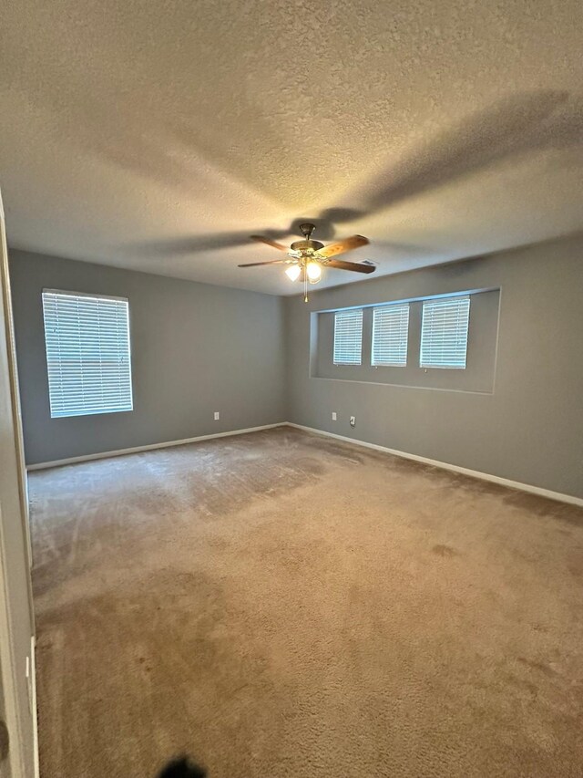 4851 Dappled Grove Trl, Humble, TX 77346 - spare room featuring light colored carpet, baseboards, a ceiling fan, and a textured ceiling