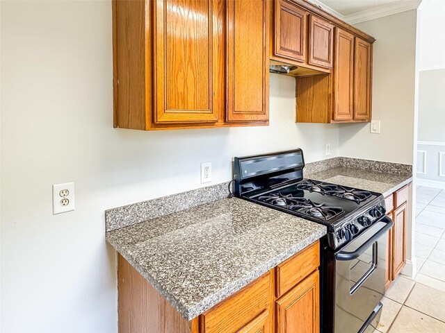 5422 Quail Cove Ln, Houston, TX 77053 - kitchen with black gas range, light tile patterned floors, brown cabinets, and crown molding