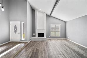 9638 Ravensworth Dr, Houston, TX 77031 - unfurnished living room with vaulted ceiling, wood finished floors, baseboards, and a large fireplace