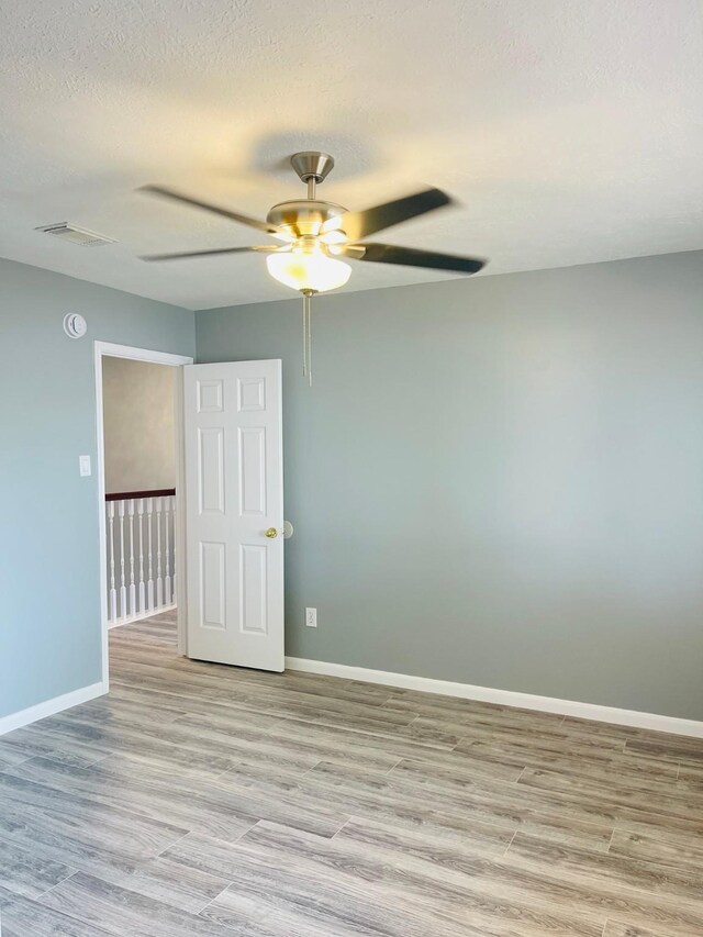 5530 Imperial Grove Dr, Houston, TX 77066 - empty room with a ceiling fan, wood finished floors, baseboards, and a textured ceiling