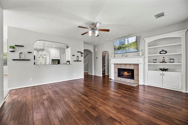 17518 Cypress Laurel St, Houston, TX 77095 - unfurnished living room featuring a ceiling fan, wood finished floors, a fireplace, and arched walkways