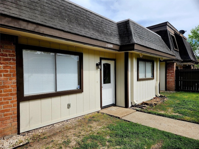 12029 Greenwood Forest Dr, Houston, TX 77066 - view of front of house with mansard roof, a shingled roof, and brick siding