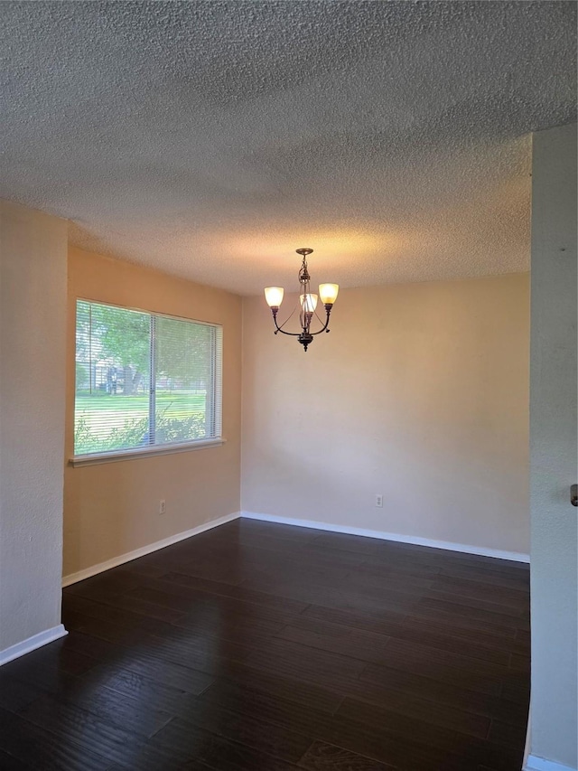 12029 Greenwood Forest Dr, Houston, TX 77066 - empty room with a chandelier, hardwood / wood-style flooring, baseboards, and a textured ceiling