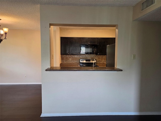 12029 Greenwood Forest Dr, Houston, TX 77066 - kitchen with appliances with stainless steel finishes, backsplash, a chandelier, wood finished floors, and dark countertops