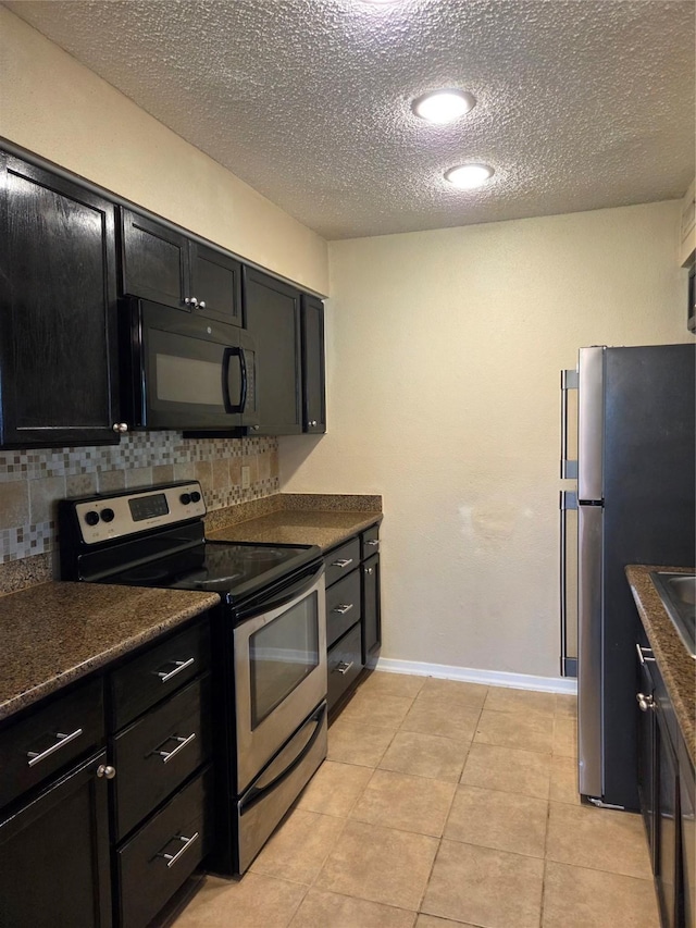12029 Greenwood Forest Dr, Houston, TX 77066 - kitchen featuring appliances with stainless steel finishes, dark cabinetry, decorative backsplash, dark countertops, and a textured ceiling