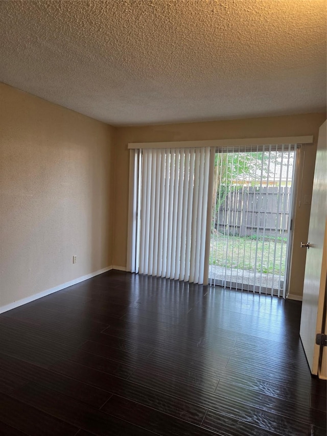 12029 Greenwood Forest Dr, Houston, TX 77066 - unfurnished room with baseboards, dark wood-style floors, and a textured ceiling