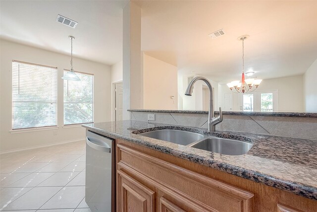 1119 Palmer St, Houston, TX 77003 - kitchen featuring a sink, dishwasher, a chandelier, brown cabinetry, and dark stone countertops