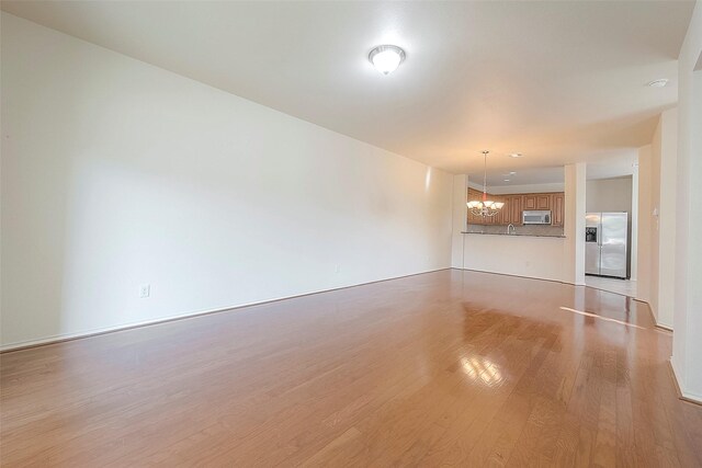 1119 Palmer St, Houston, TX 77003 - unfurnished living room featuring a chandelier and light wood-type flooring