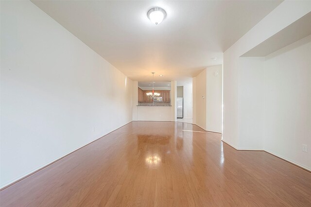 1119 Palmer St, Houston, TX 77003 - unfurnished living room featuring light wood finished floors and a chandelier