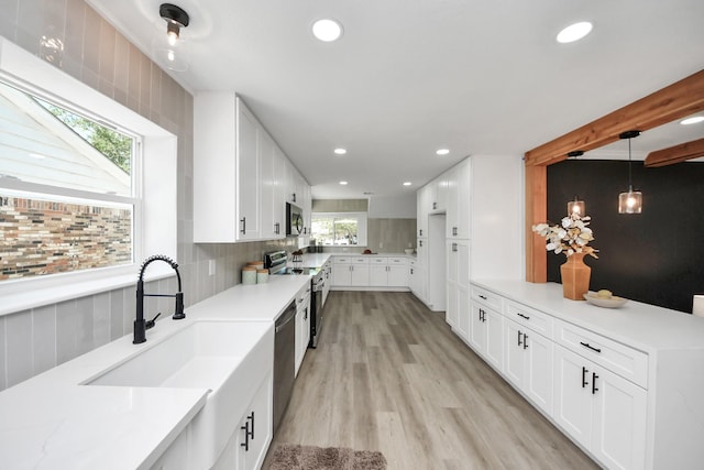 702 Cedar Ln, El Lago, TX 77586 - kitchen with appliances with stainless steel finishes, a sink, light wood-type flooring, light countertops, and recessed lighting