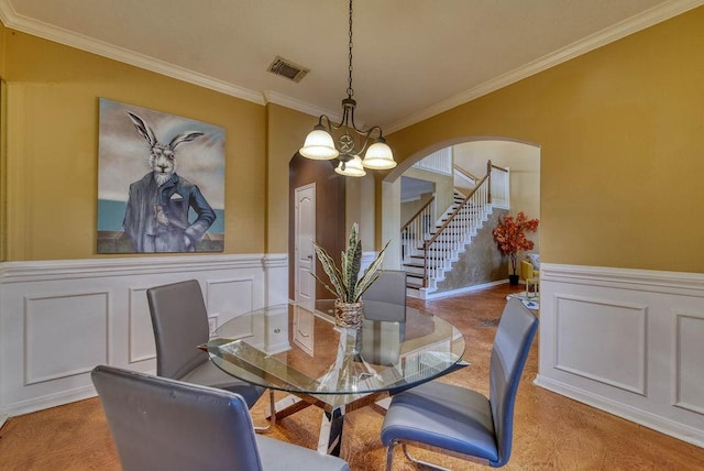 1114 Carriage Ct, Seabrook, TX 77586 - dining space featuring a decorative wall, ornamental molding, arched walkways, a wainscoted wall, and stairs