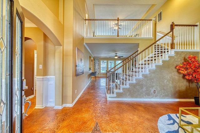 1114 Carriage Ct, Seabrook, TX 77586 - foyer featuring arched walkways, stairway, baseboards, a ceiling fan, and a high ceiling
