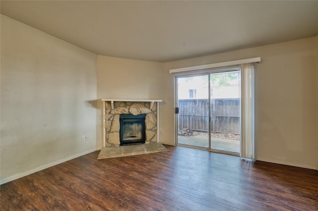 6001 Reims Rd Unit 1207, Houston, TX 77036 - unfurnished living room featuring wood finished floors, a stone fireplace, and baseboards