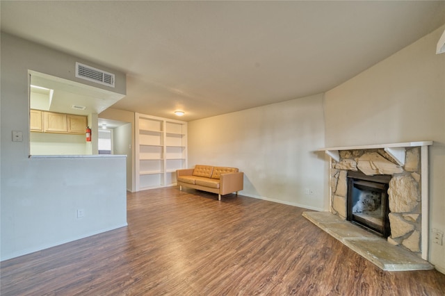 6001 Reims Rd Unit 1207, Houston, TX 77036 - sitting room featuring wood finished floors, a stone fireplace, baseboards, and built in shelves