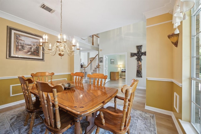 2 Slatestone Cir, The Woodlands, TX 77382 - dining space with wood finished floors, stairs, a chandelier, ornamental molding, and baseboards