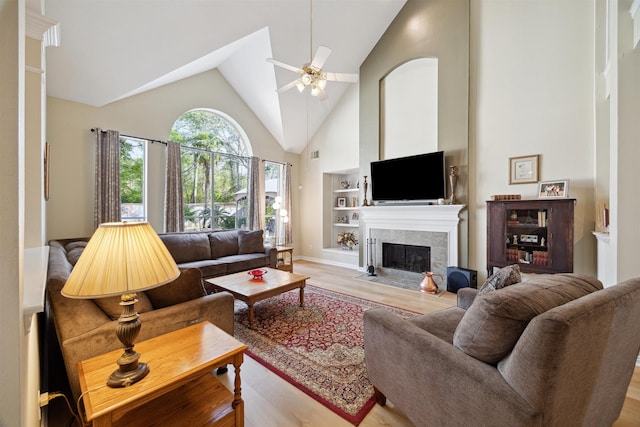 2 Slatestone Cir, The Woodlands, TX 77382 - living area featuring light wood-type flooring, high vaulted ceiling, ceiling fan, a fireplace, and built in shelves