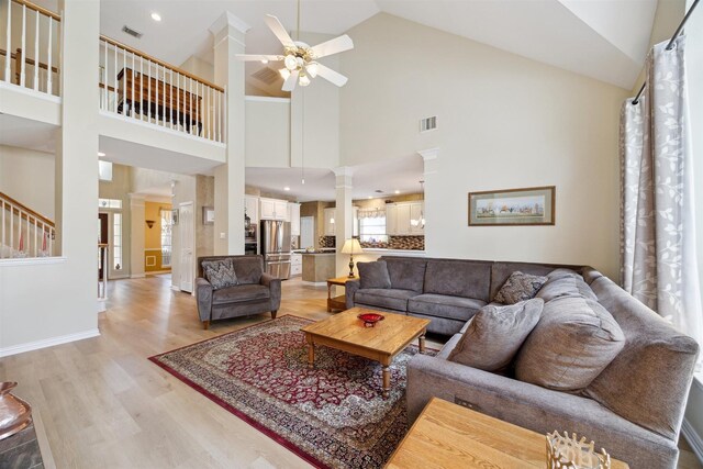 2 Slatestone Cir, The Woodlands, TX 77382 - living area featuring a ceiling fan, light wood-type flooring, high vaulted ceiling, ornate columns, and baseboards