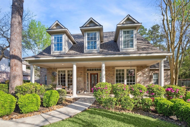 2 Slatestone Cir, The Woodlands, TX 77382 - view of front of house featuring brick siding, a porch, and roof with shingles