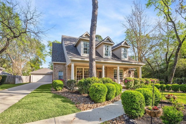 2 Slatestone Cir, The Woodlands, TX 77382 - new england style home featuring brick siding, covered porch, a detached garage, and a shingled roof