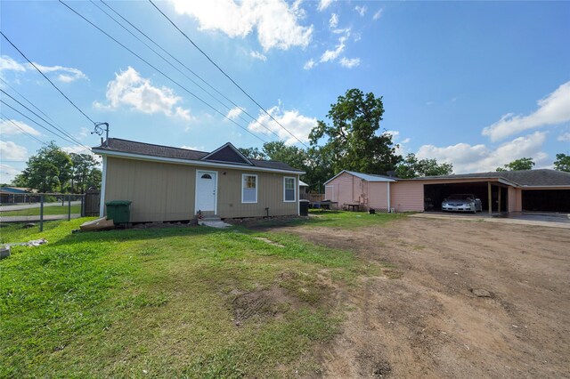 3810 Hurley St, Houston, TX 77093 - view of front of property featuring dirt driveway, a carport, and an outbuilding