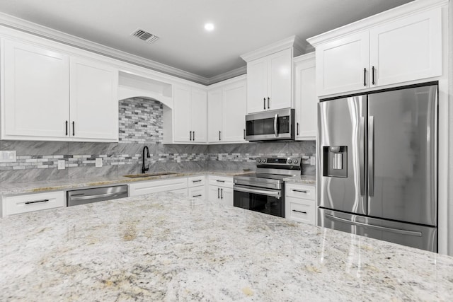 247 Mistletoe, Onalaska, TX 77360 - kitchen with appliances with stainless steel finishes, a sink, white cabinets, tasteful backsplash, and light stone countertops