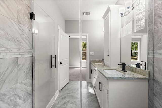 247 Mistletoe, Onalaska, TX 77360 - full bathroom with marble look tiles, double vanity, a stall shower, and baseboards