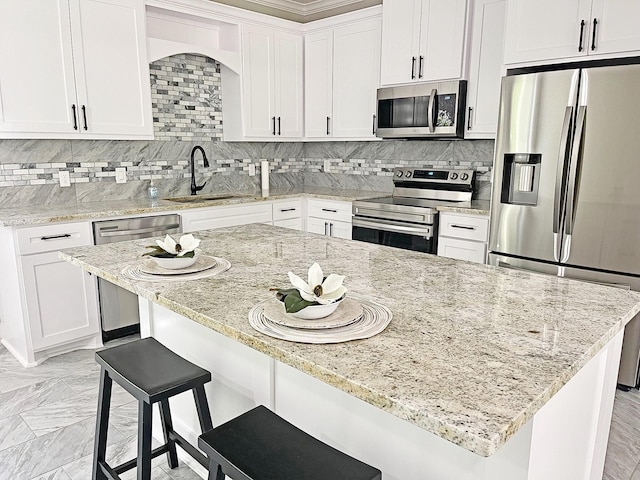 247 Mistletoe, Onalaska, TX 77360 - kitchen featuring appliances with stainless steel finishes, a sink, decorative backsplash, and white cabinets
