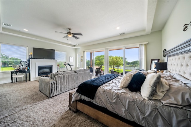 11434 Ketch Ct, Willis, TX 77318 - carpeted bedroom featuring access to outside, multiple windows, a glass covered fireplace, recessed lighting, and ceiling fan