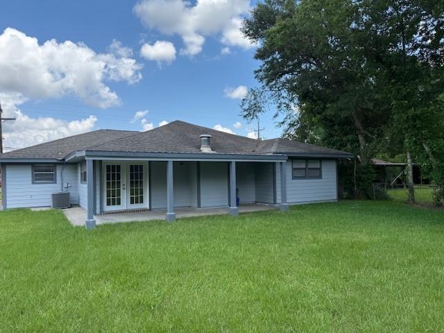8615 Washington Blvd, Beaumont, TX 77707 - back of property featuring french doors, a lawn, and central AC