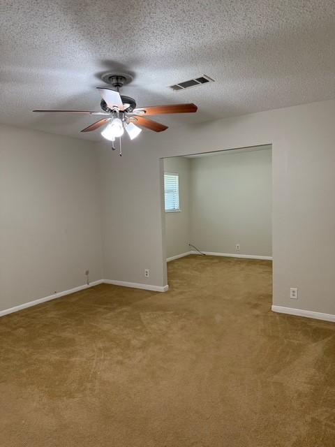 8615 Washington Blvd, Beaumont, TX 77707 - spare room featuring carpet flooring, ceiling fan, a textured ceiling, and baseboards