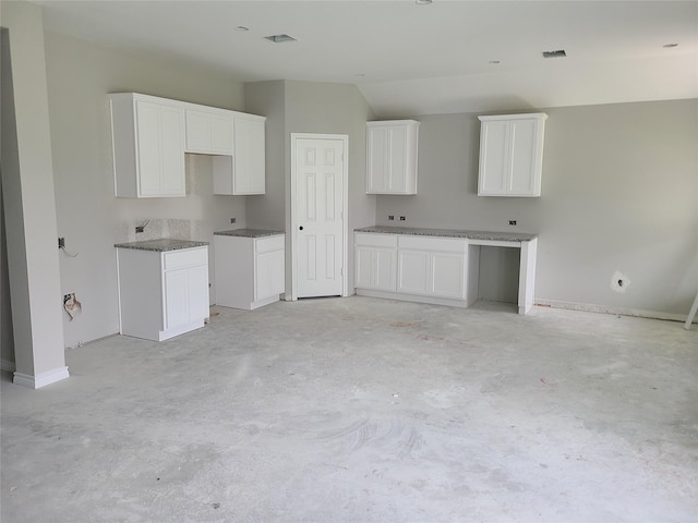 1617 14th Ave N, Texas City, TX 77590 - kitchen featuring unfinished concrete floors, lofted ceiling, and white cabinets